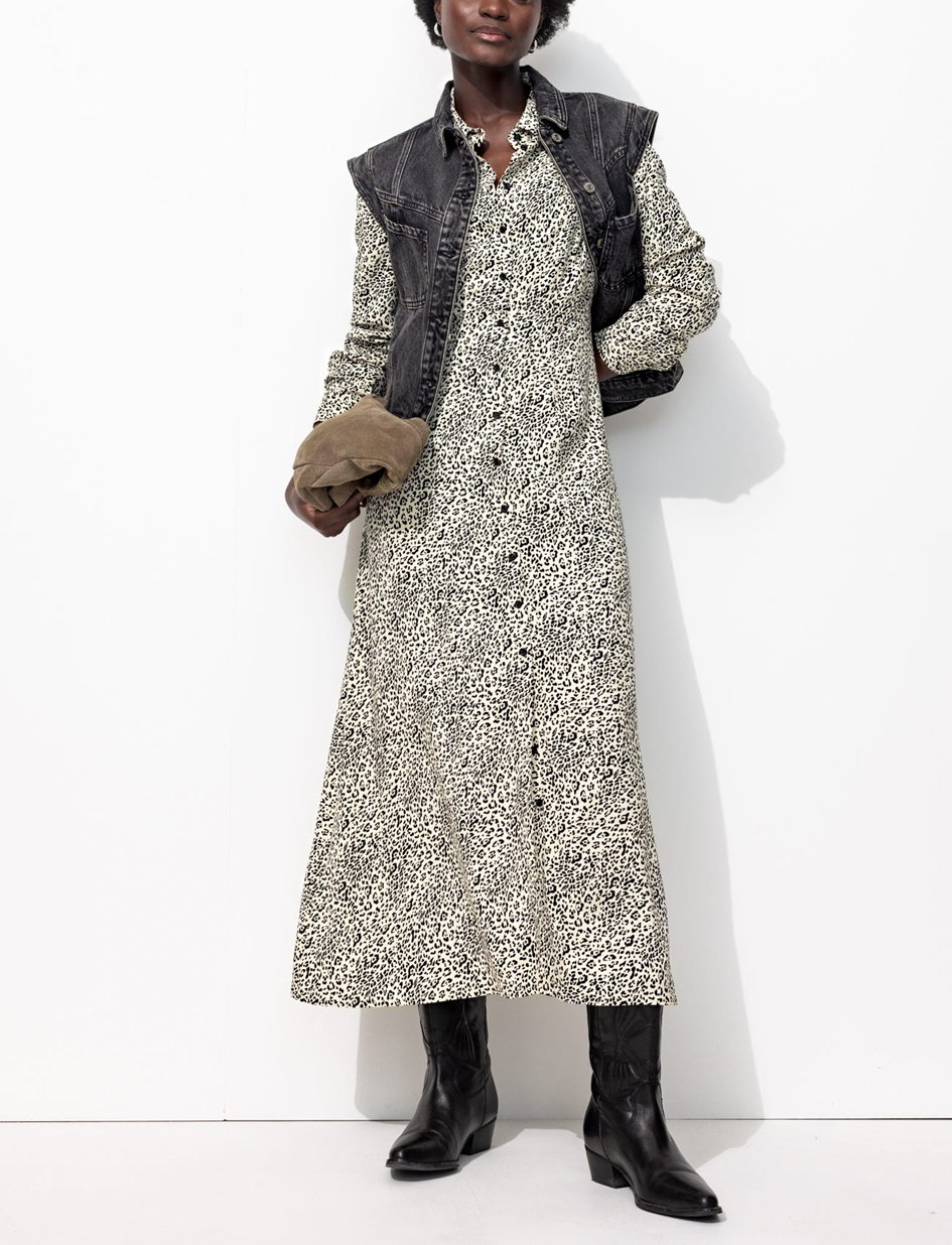 mannequin portant une veste en jean sans manche grise avec une robe-chemise léopard longue 