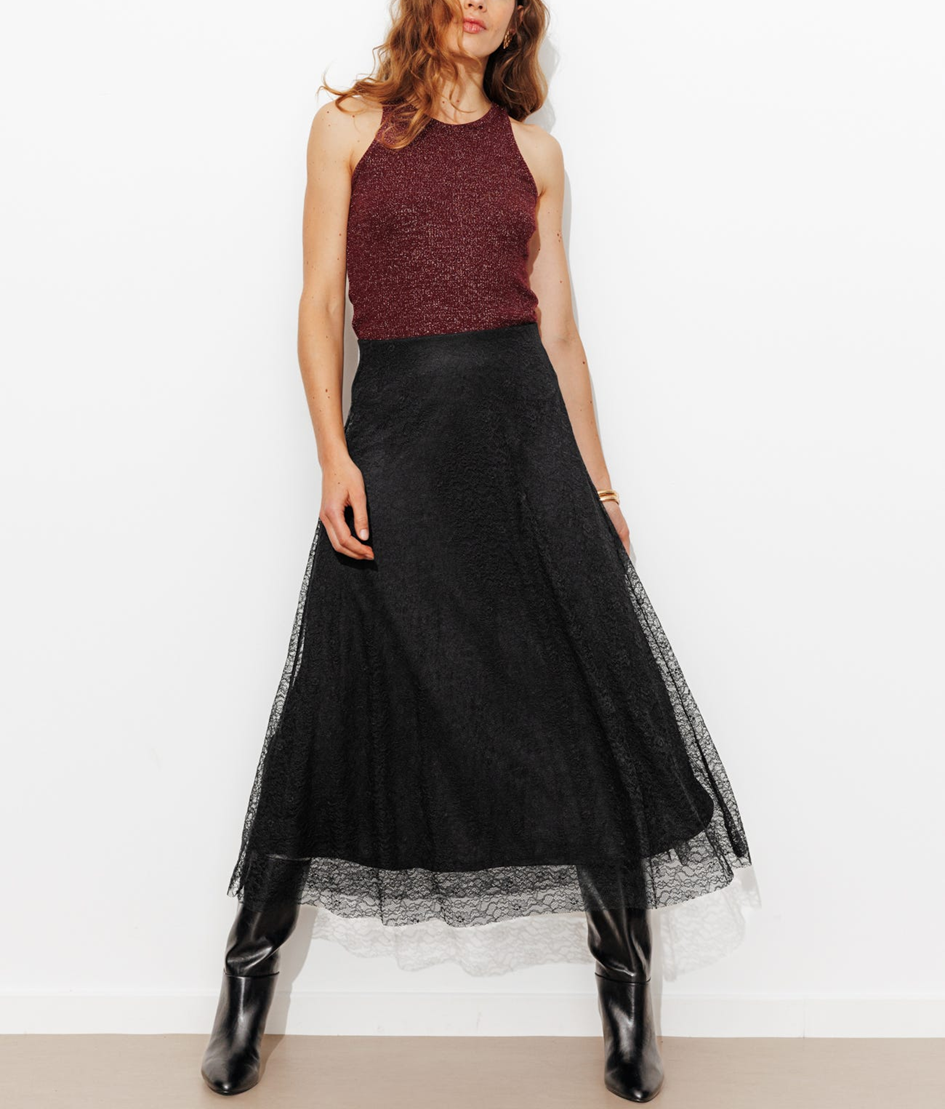 mannequin portant une jupe longue en dentelle, avec un débardeur à paillettes 