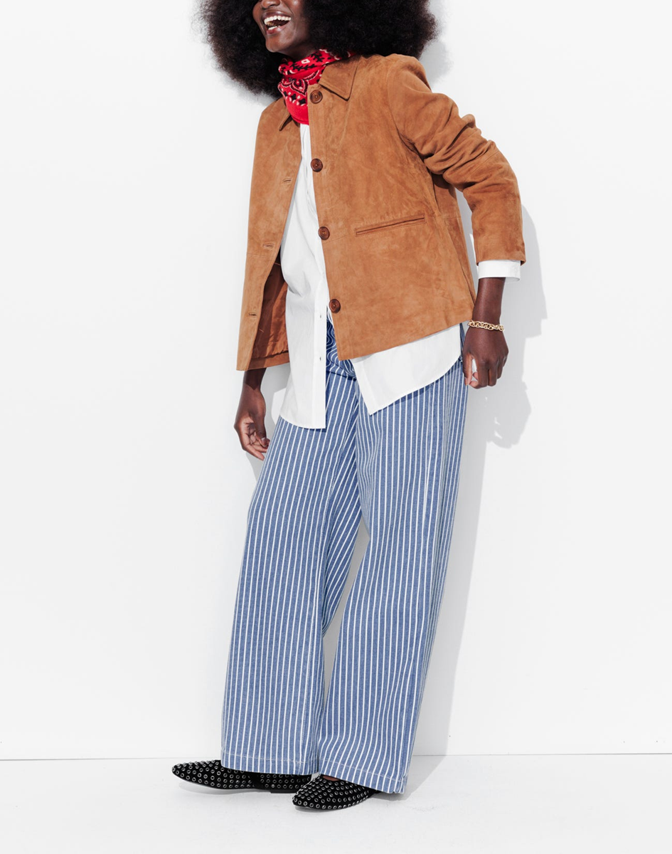 mannequin portant un pantalon large en toile rayé, avec une veste courte en cuir et une chemise