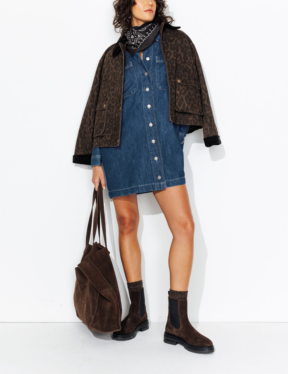 mannequin portant une robe en jean avec un foulard bandana, une veste léopard sur ses épaules et un sac cabas avec des bottines 