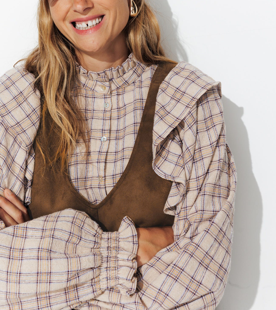 mannequin portant une robe velours peu de pêche avec une chemise à carreau en dessous