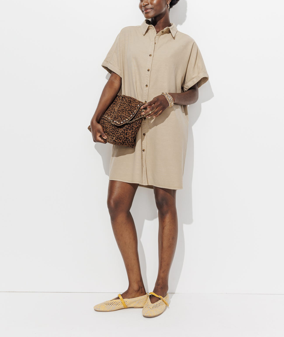 mannequin portant une robe chemise beige avec un sac léopard