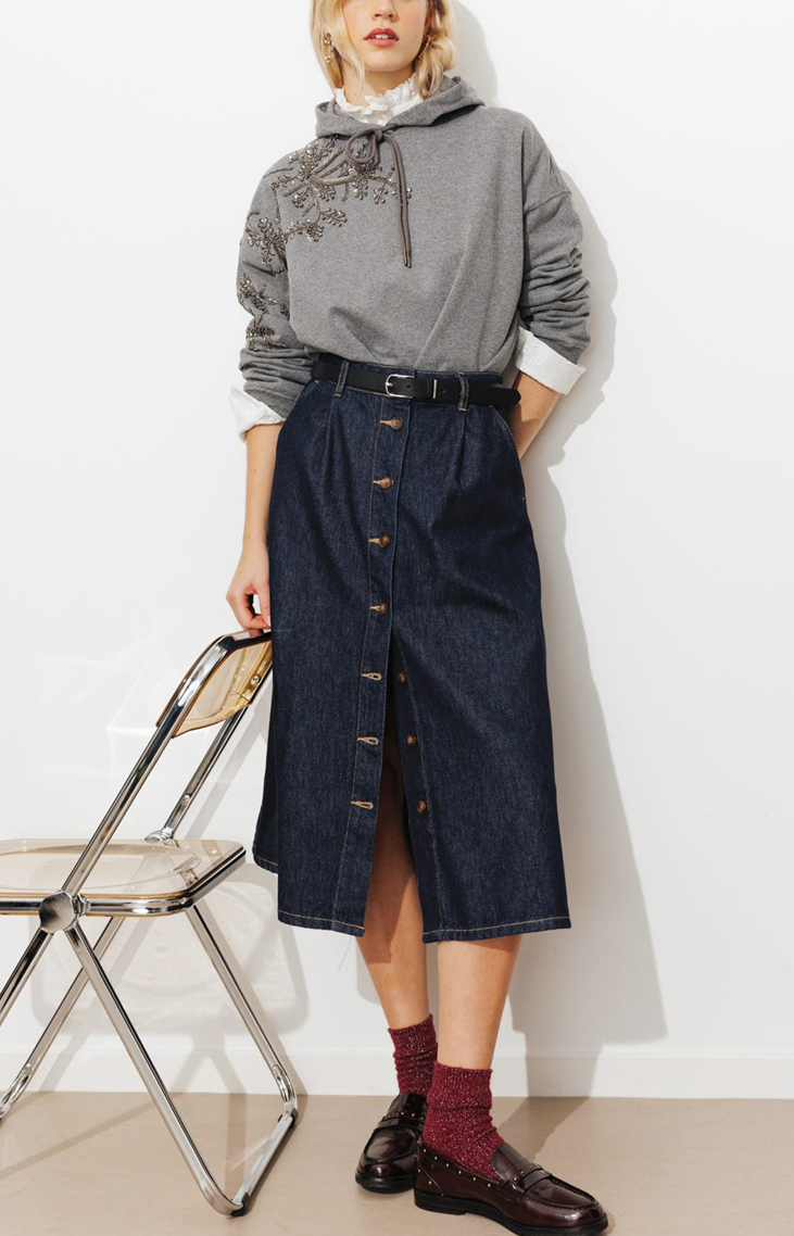 Denim brut 100% coton. Coupe évasée, longueur midi. Pinces devant. Taille haute, passants. Ouverture boutonnée devant. 2 poches italiennes. Base arrondie. Coutures contrastées.