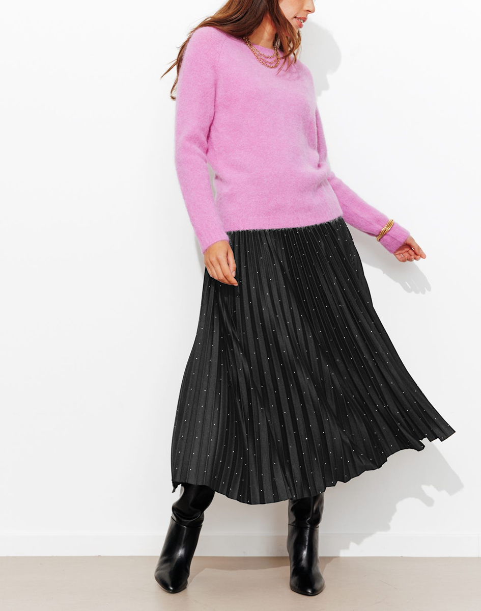 mannequin portant une jupe plissé à paillettes avec un pull rose