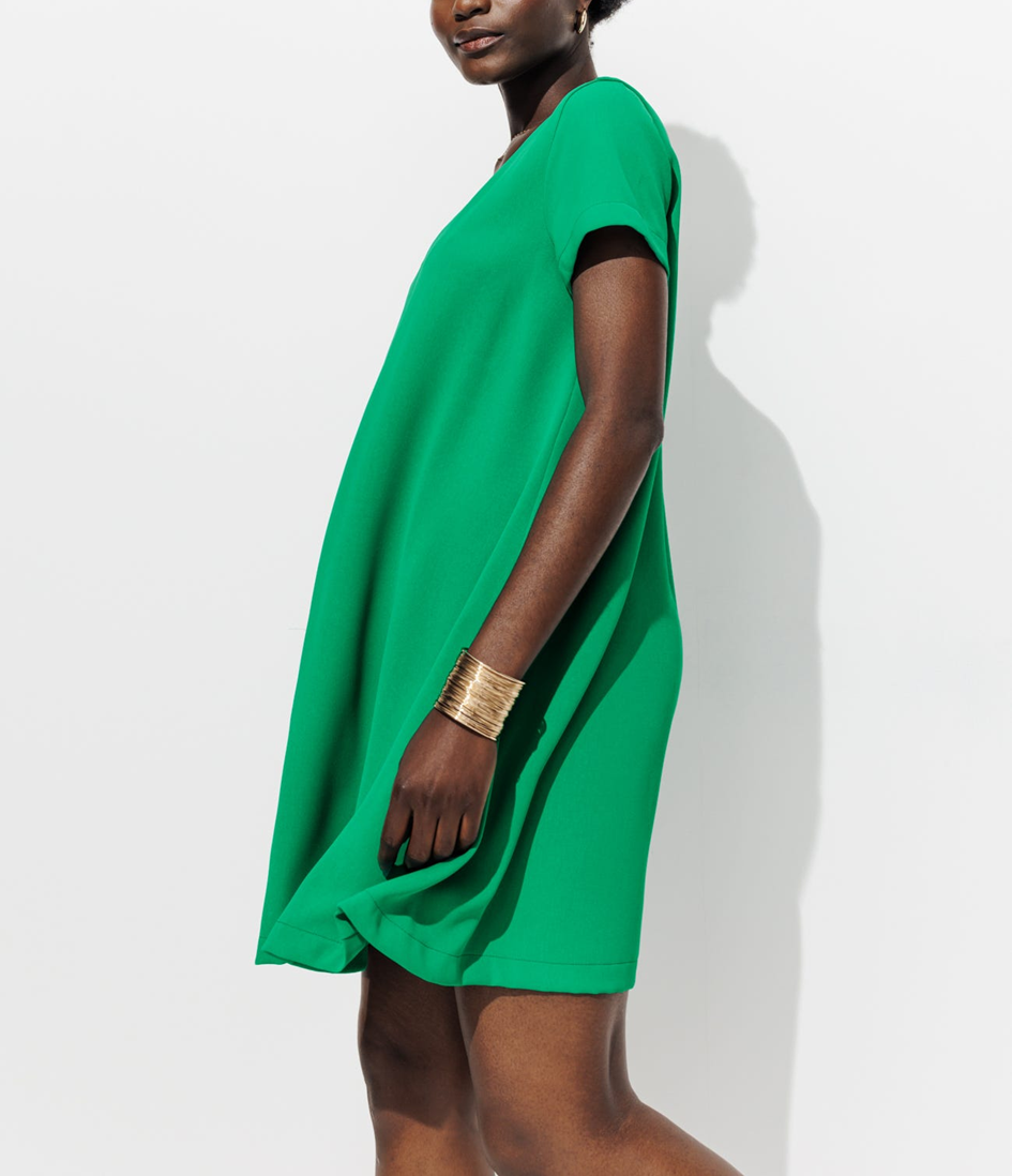 Mannequin portant une robe courte fluide verte avec un bracelet doré