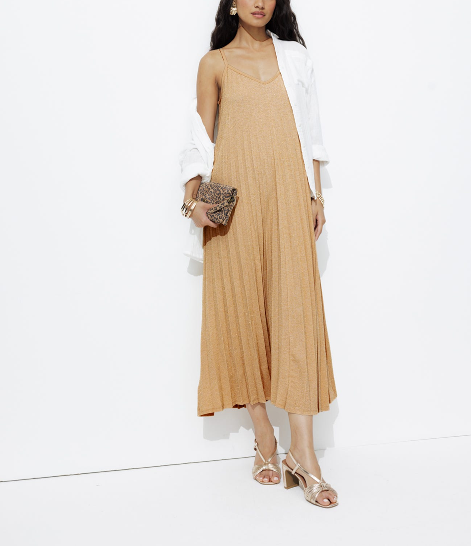 mannequin portant une robe longue plissée uni avec des talons nudes avec une pochette léopard et boucle d'oreilles et des bracelets