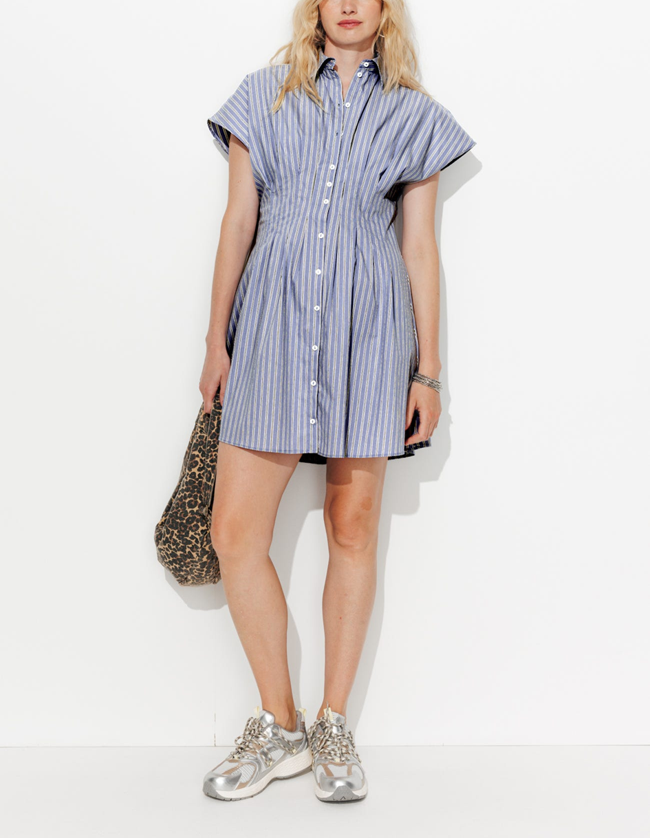 mannequin portant une robe chemise rayé, avec un style décontracté dont des baskets et un sac léopard 