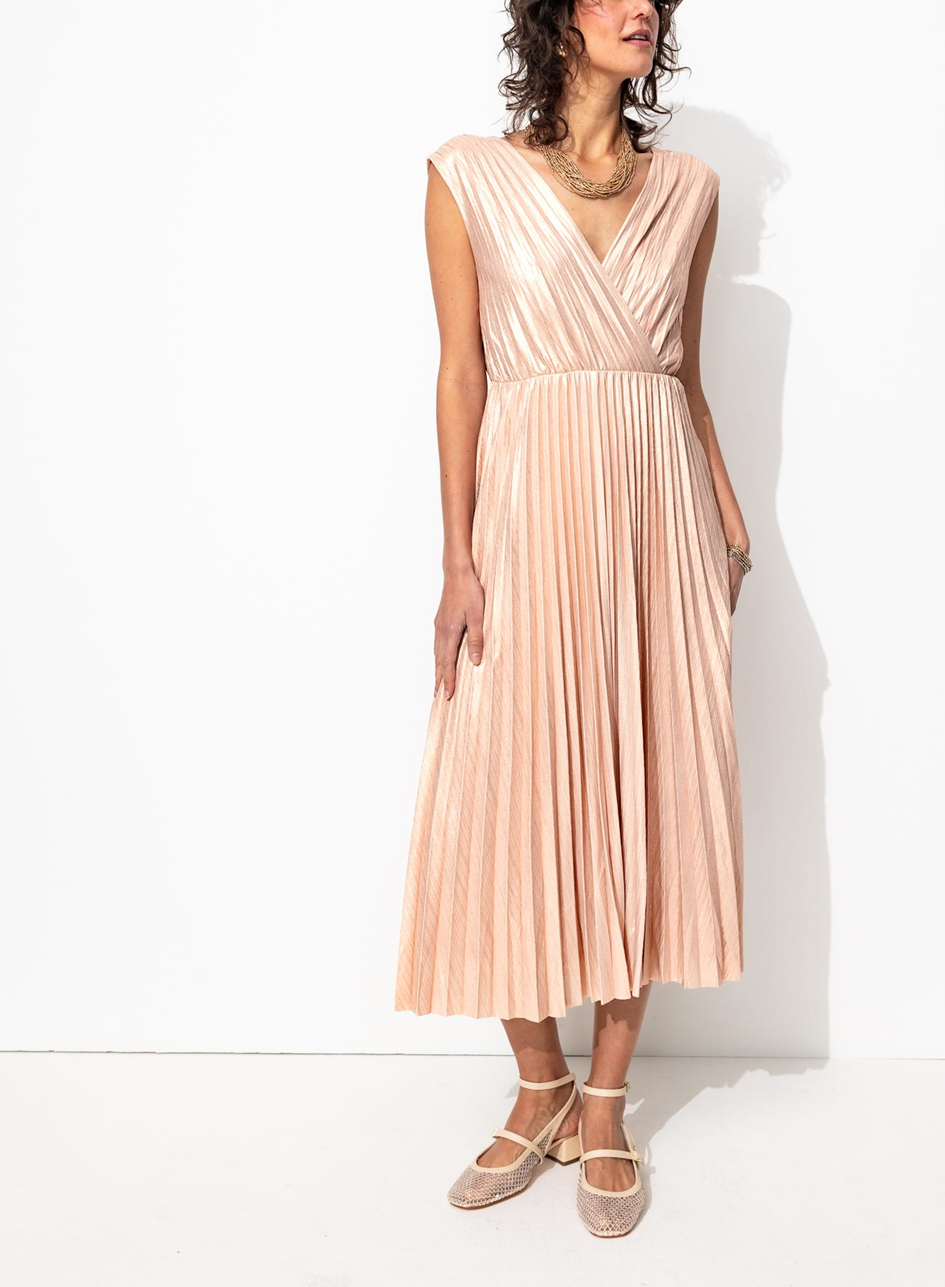 mannequin portant une robe midi plissée lamée rose pâle. Coupe fluide, évasée